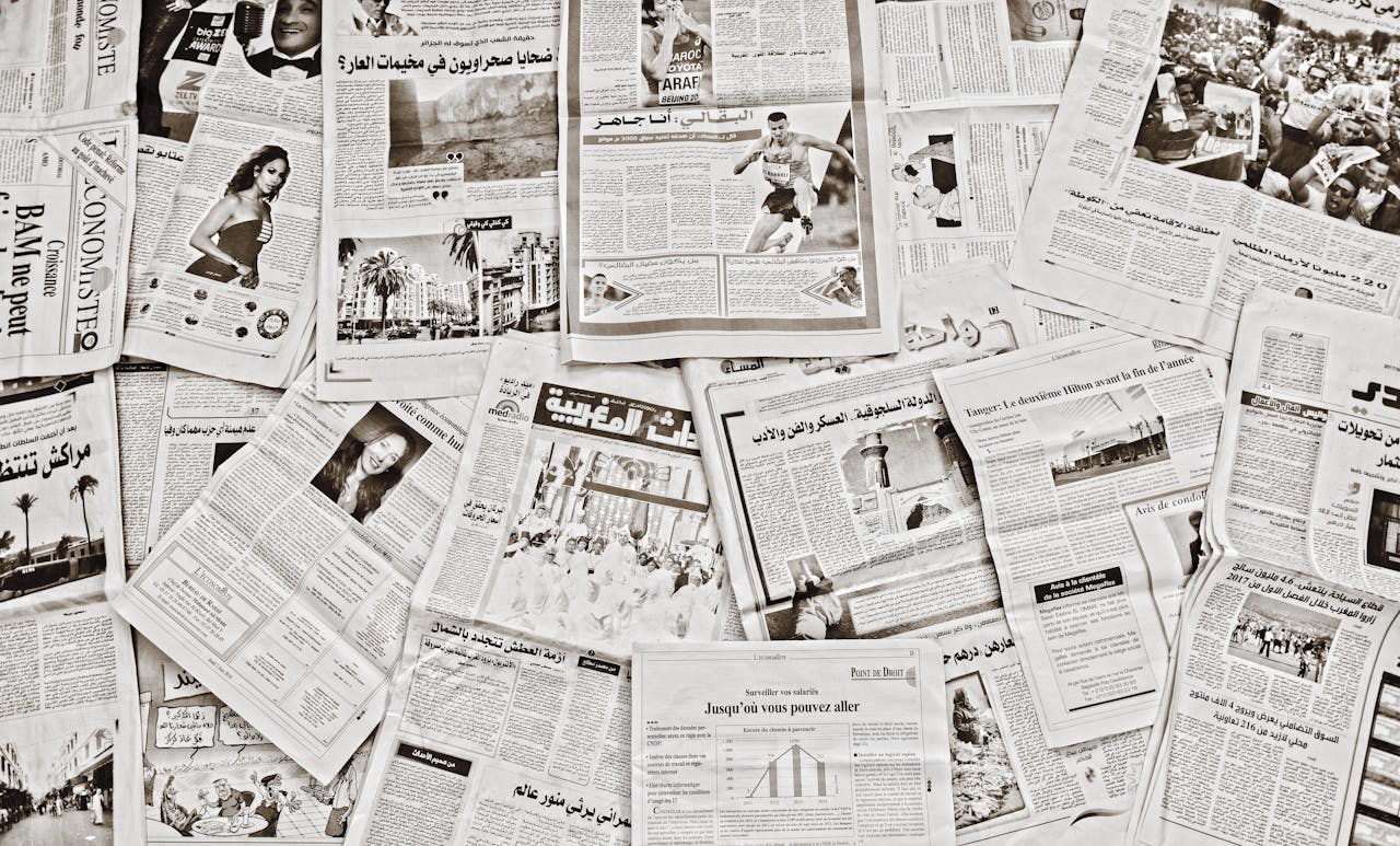 our-experience A flat lay of Arabic newspapers in Fès, Morocco, showcasing diverse articles.